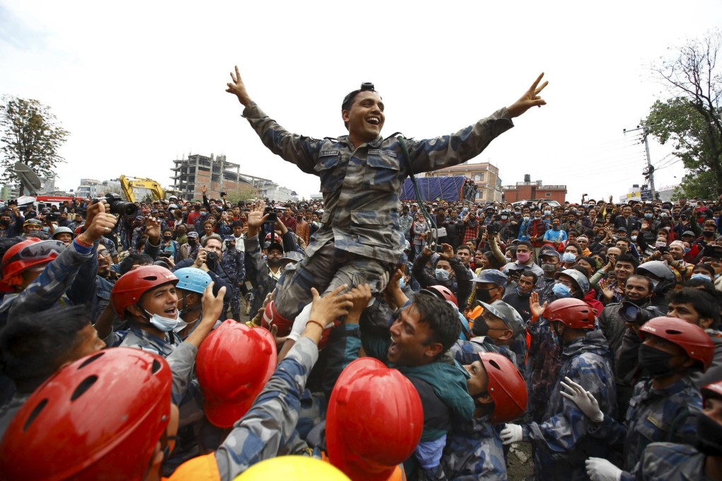 Rescuers rejoice after pulling out a survivor. Photo: Reuters