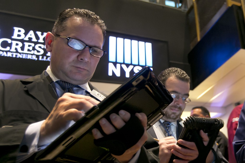 A trader on the floor of the New York stock exchange jots down orders as all US indices lost ground during Thursday's session. Photo: AP