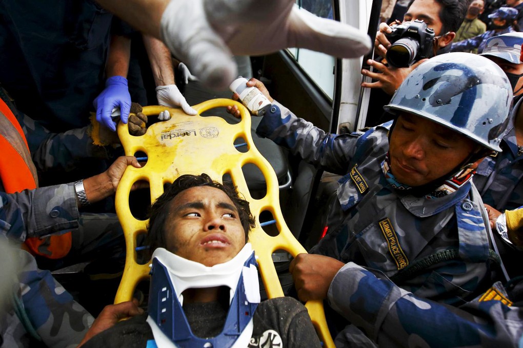 Pemba Lama is rescued from a collapsed guesthouse. Photo: Reuters