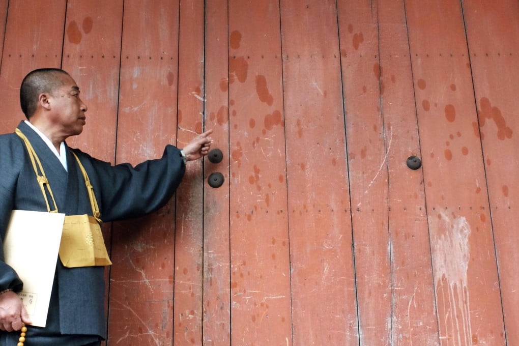 Priests point to oily spots at Kanjoin Hall at Toji Temple (left) in Kyoto and at Great South Gate of Todaiji temple in Nara.Photos: Kyodo