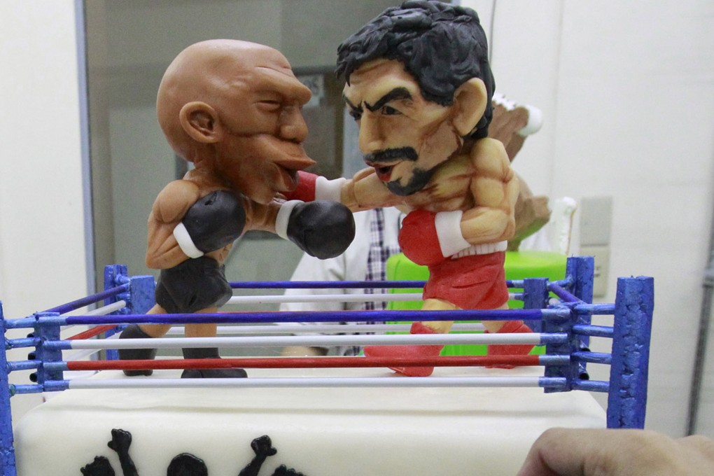 A two-layer cake featuring fondant caricatures of boxers Floyd Mayweather Jnr and Manny Pacquiao in a boxing ring is shown to the media at a bakery in Manila, Philippines. Photo: Reuters