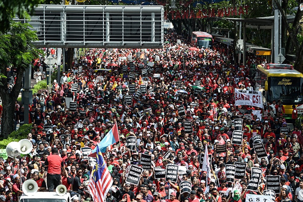 Protesters march towards Malaysia's landmark Petronas Twin Towers during a May Day protest against a goods and services tax in Kuala Lumpur on Friday. Photo: AFP