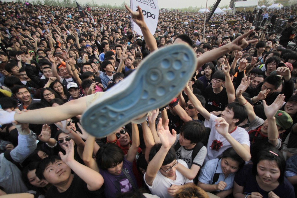 A rock fan is lifted as he crowd surfs during a performance at the 2012 Strawberry Music Festival at Tongzhou Canal Park in Beijing. Photo: Reuters