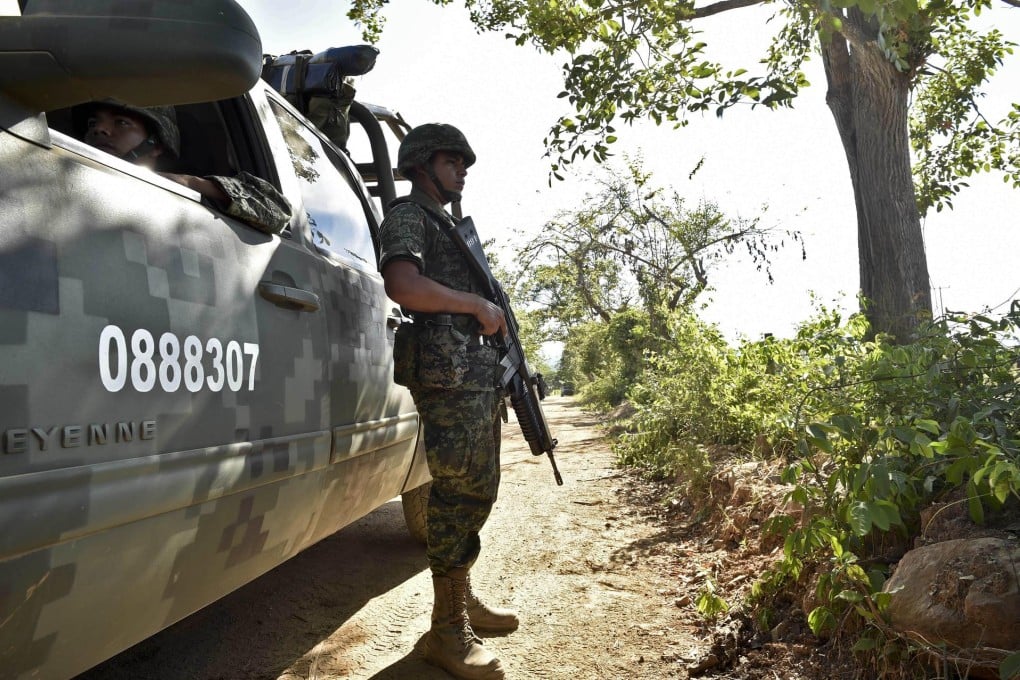 A Mexican soldier on patrol where a military helicopter on a mission with police was shot down in the Villa Vieja community.Photo: AFP