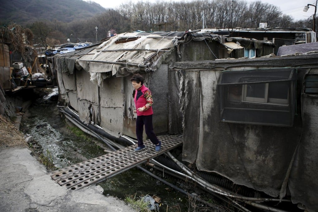 A woman crosses a bridge in Guryong village.Photo: Reuters