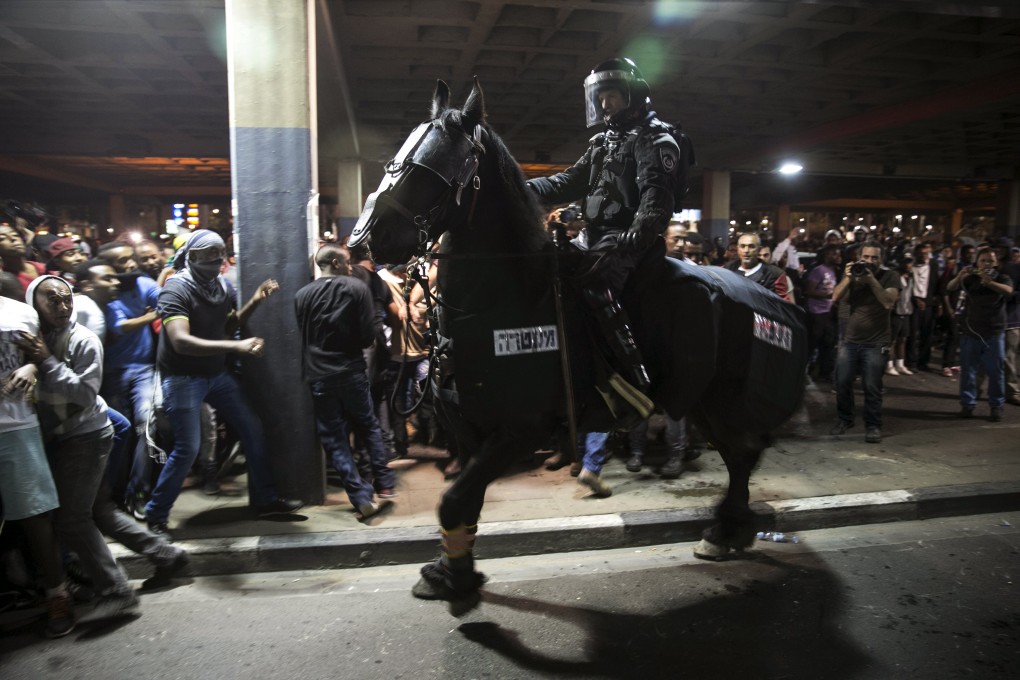 A policeman on horseback charges ethnic Ethiopians protesting against racism in Tel Aviv on Sunday night. Photo: Reuters