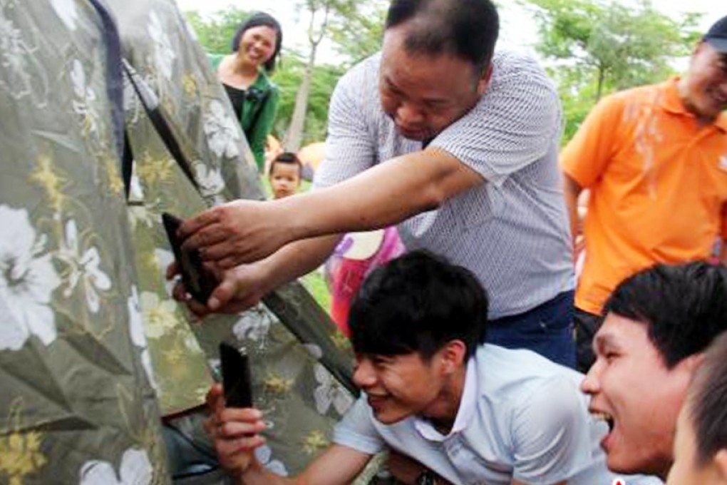 Tourists taking photographs of people chatting in a tent during the dating event. Photo: Chinanews.com