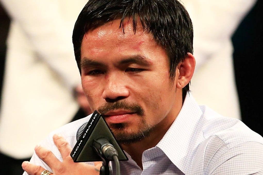 Manny Pacquiao points to his right shoulder during the post-fight news conference after losing to Floyd Mayweather in their welterweight unification championship bout on May 2, 2015. Photo: AFP