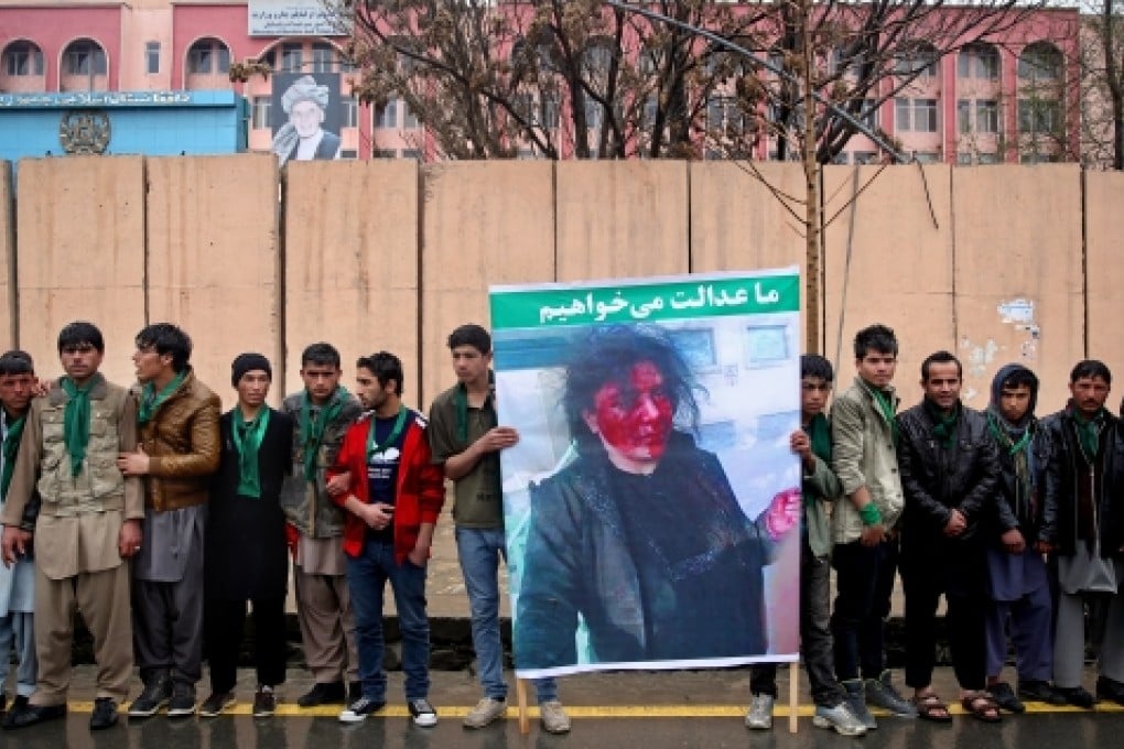 Afghan men holding a banner showing the bloodied face of lynching victim Farkhunda stand in front of the Supreme Court during a protest demanding justice, months before today's verdict. Photo: AP