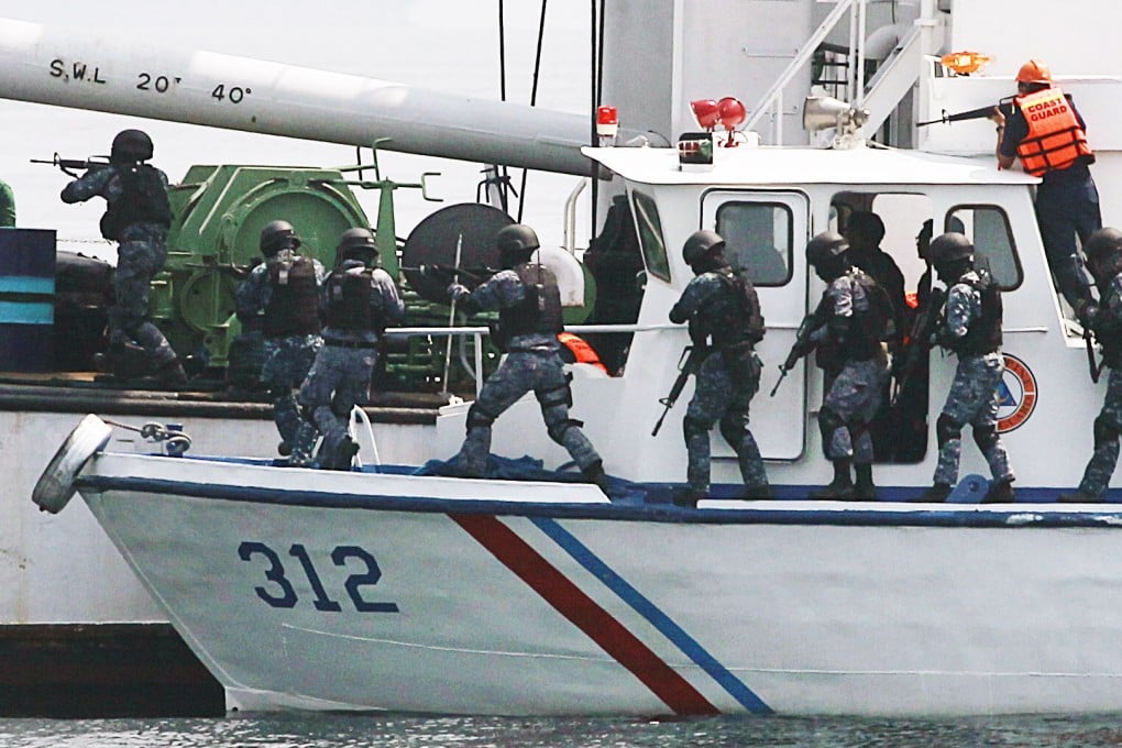 Members of the Philippine Coast Guard (PCG) anti-terrorist unit board a cargo vessel to engage mock pirates who hijacked the vessel during a  combined maritime law enforcement exercise at a bay in Manila. Photo: Reuters