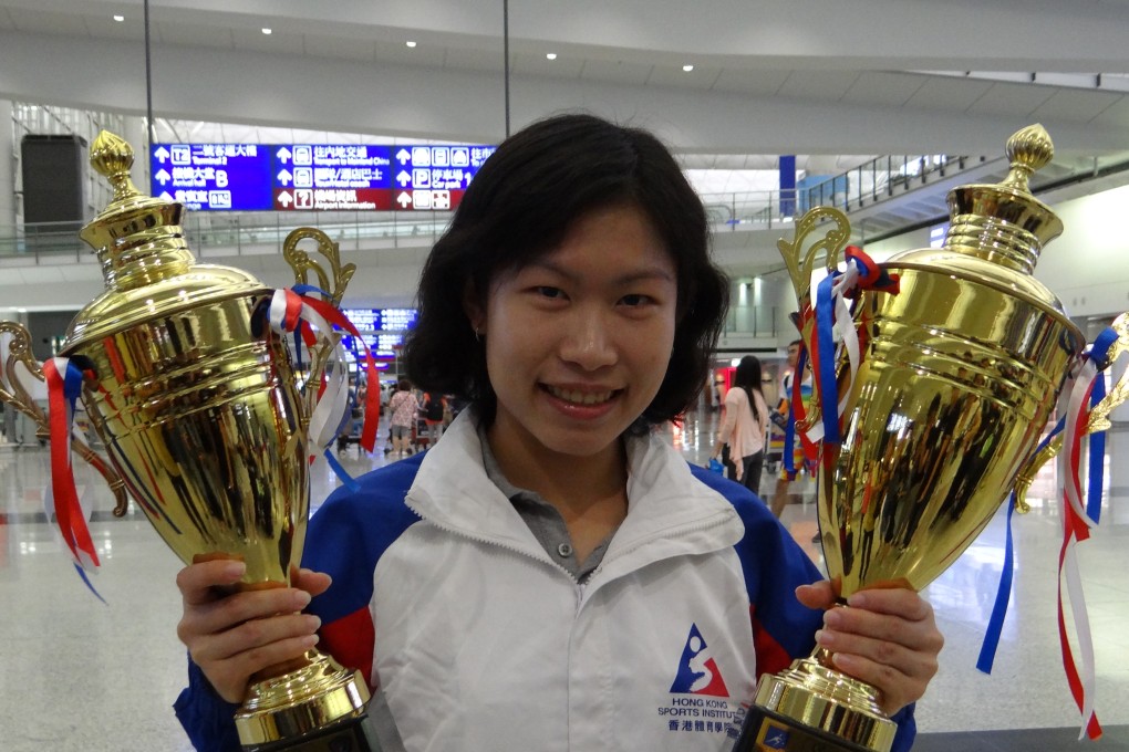 Annie Au with her trophy (left) and brother Leo's trophy on arriving back in Hong Kong. Photo Kevin Kung