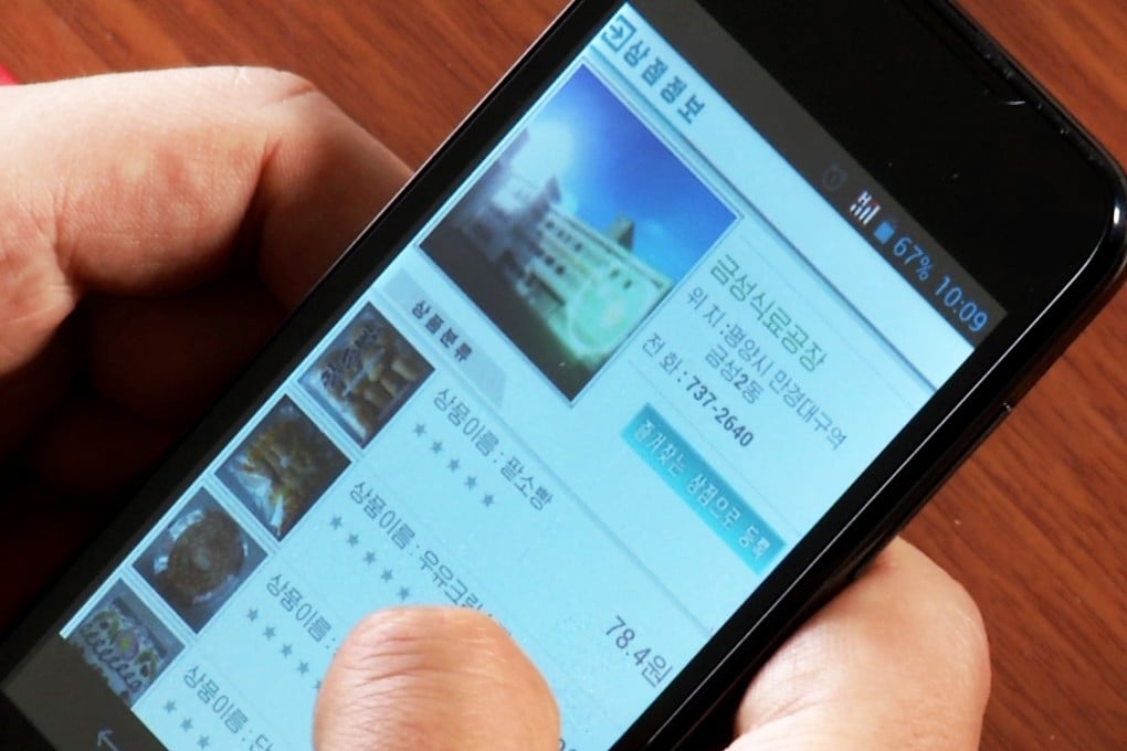 In this April 22 image taken from APTN, a man uses his smartphone to demonstrate how to use North Korea's new online shopping site. Photo: AP