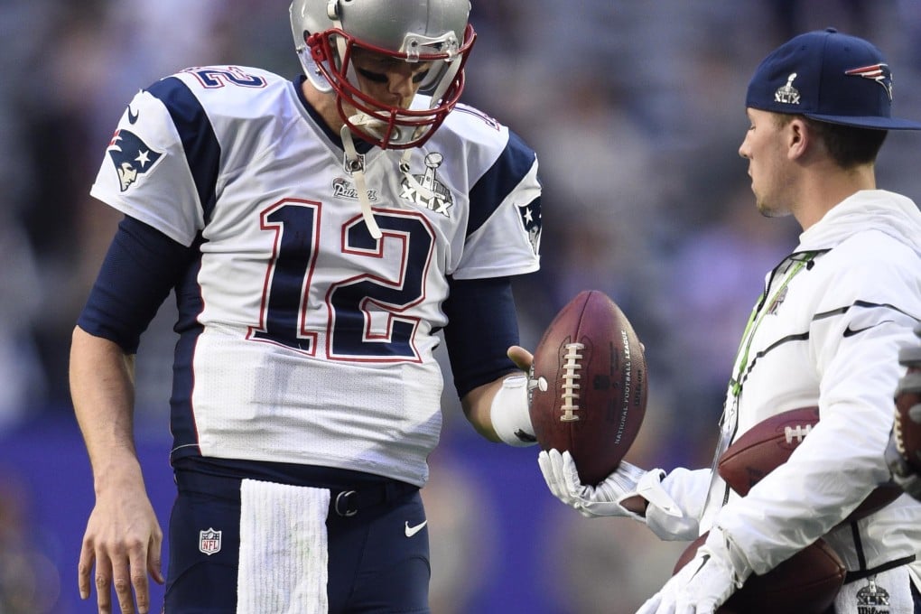 Tom Brady takes a ball from a ball boy at the Super Bowl. Photo: USA Today