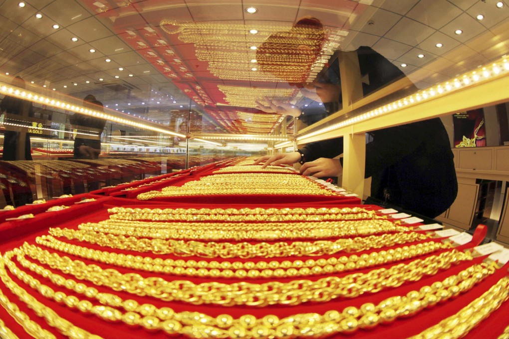 A sales assistant arranges gold necklaces at a store in Lianyungang, in Jiangsu province. Reuters