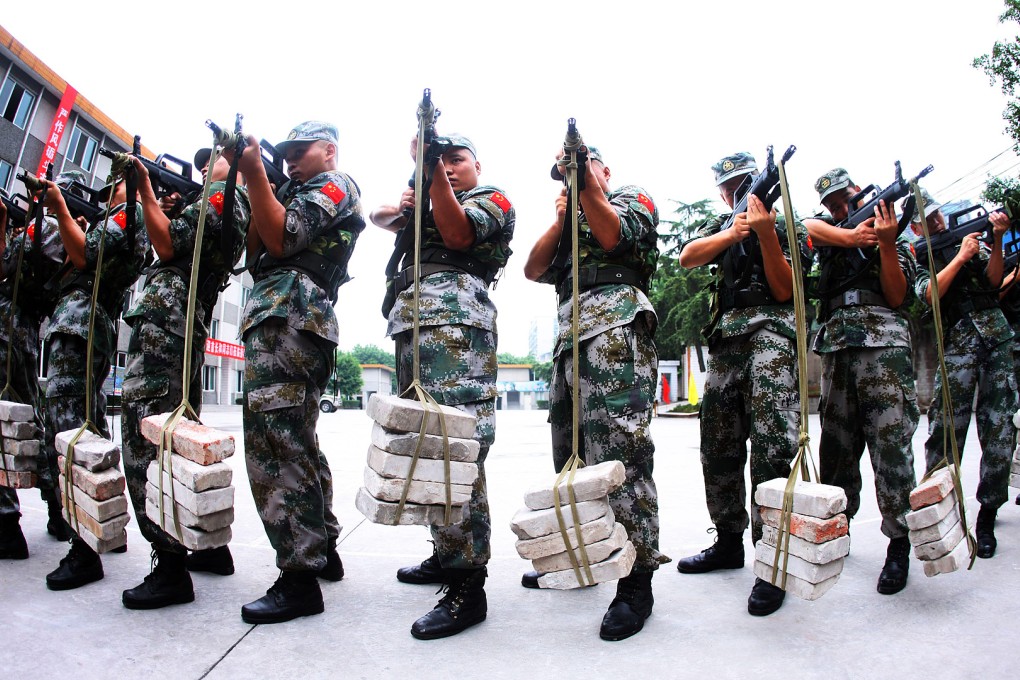 PLA soldiers learning how to keep their guns steady during training at their base in Luzhou. China's defence budget will rise about 10 per cent this year. Photo: AFP