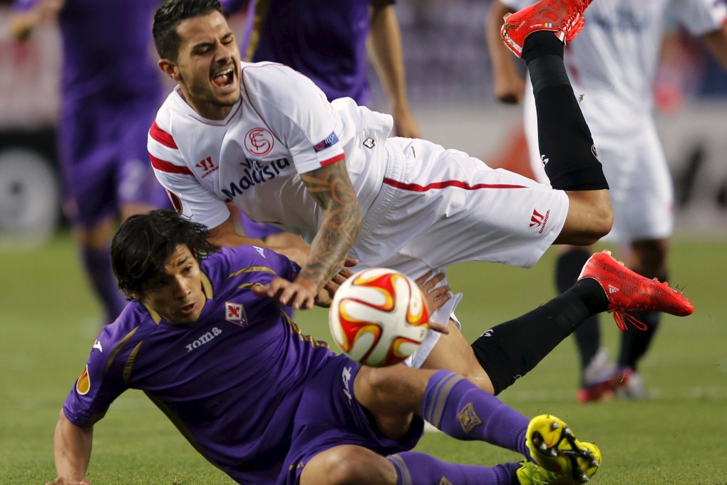 Sevilla's Victor Machin "Vitolo" is taken down by Fiorentina's Matias Fernandez. Photo: Reuters