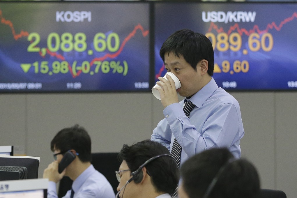 A foreign currency trader in Korea takes a drink to catch his breath. China's yuan weakened on Friday while the pound firmed on news the Conservative party in the UK will stay in office. Photo: AP