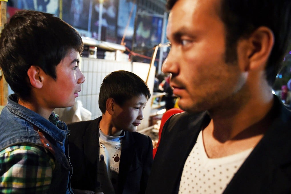 Uygur men visiting a night market in Hotan. Some Uygurs allege that ethnic Han settlers in Xinjiang receive preferential treatment. Photo: AFP
