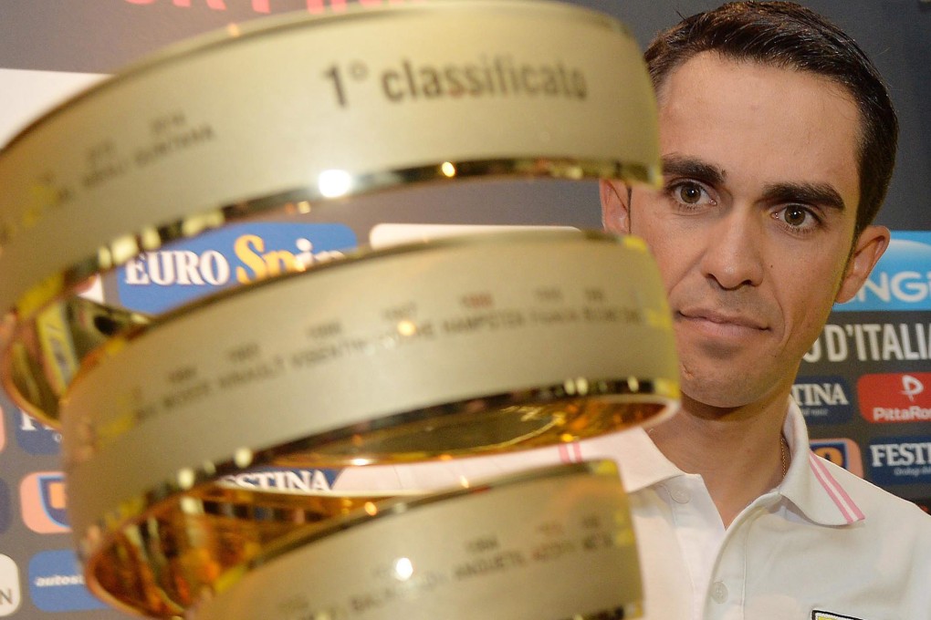 Spaniard Alberto Contador of Tinkoff-Saxo inspects the Giro d'Italia trophy at a press conference in San Lorenzo al Mare, Italy. Photo: EPA