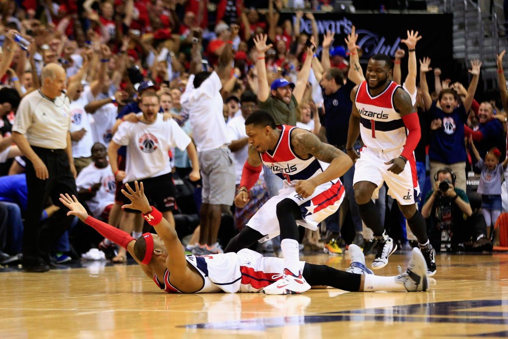Paul Pierce, of the Washington Wizards, collapses to the floor to celebrate his winning shot with teammate Bradley Beal in their game against the Atlanta Hawks. Photo: AFP