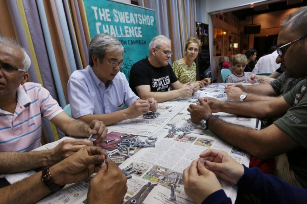 Volunteers including Mekong Club chairman Matthew Friedman (centre in black top) take part in the Sweatshop Challenge. Photo: Nora Tam
