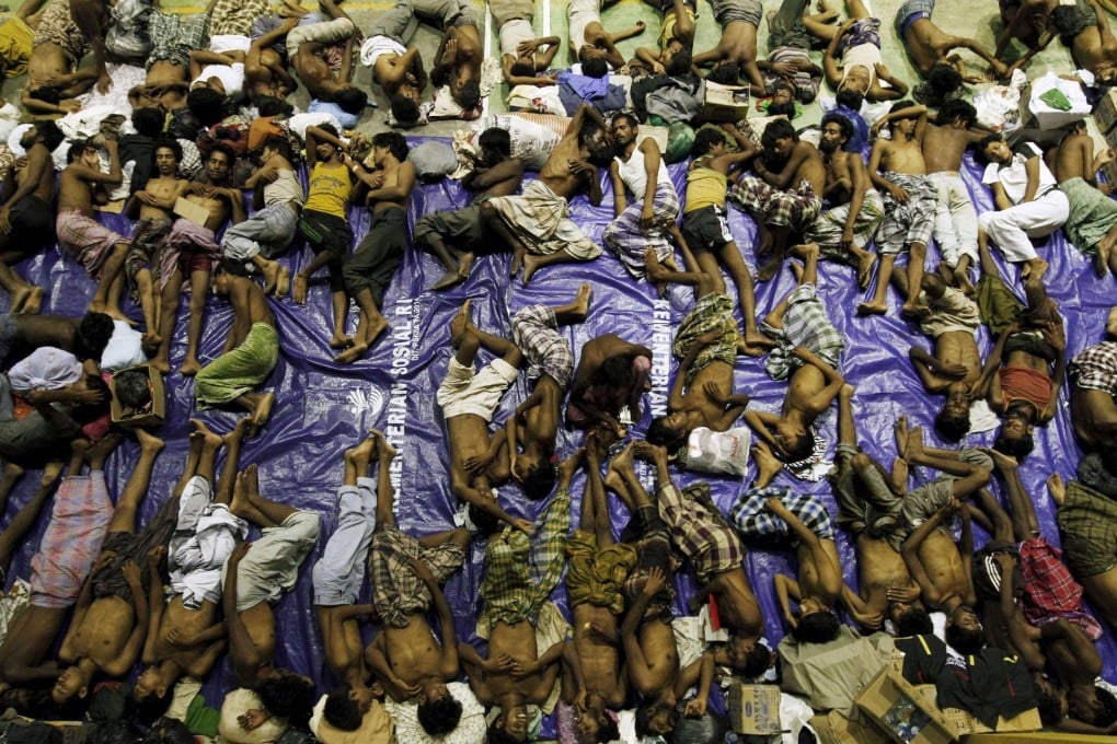 Migrants who are believed to be Rohingya Muslims rest inside a shelter after being rescued from two wooden boats that had run out of fuel and were towed to shore at Lhoksukon in Indonesia's Aceh Province. Photo: Reuters
