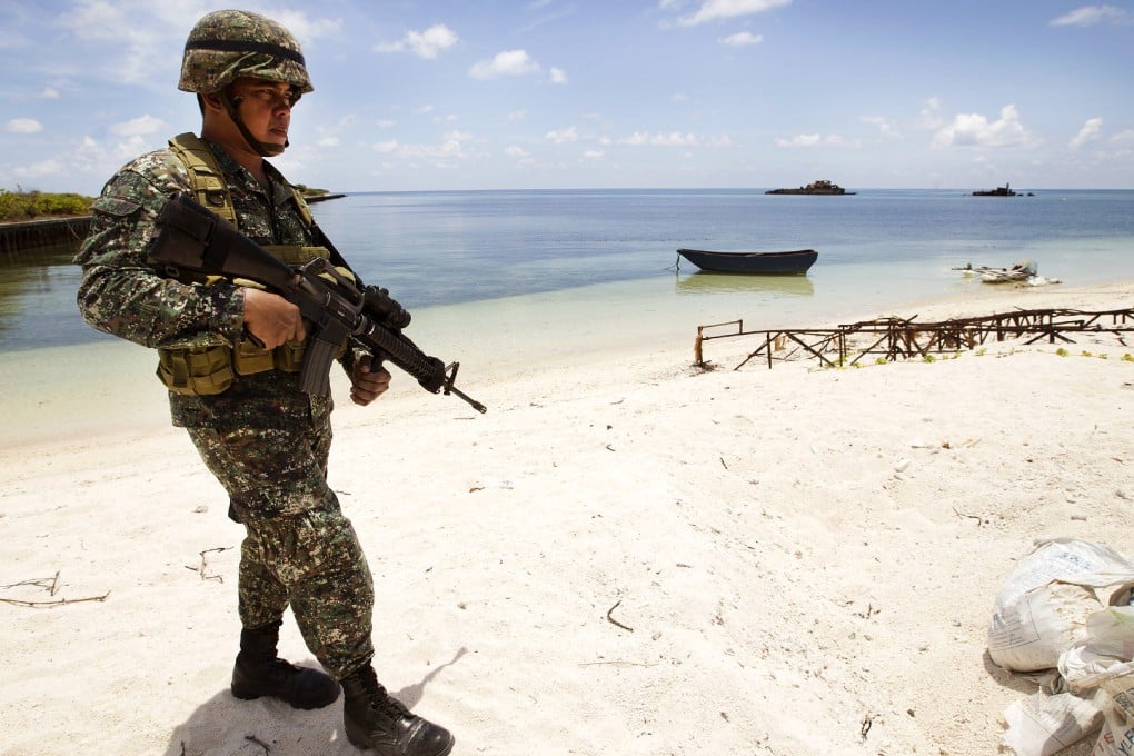 A Filipino soldier patrols the shore of Pagasa Island in the South China Sea. Photo: AP