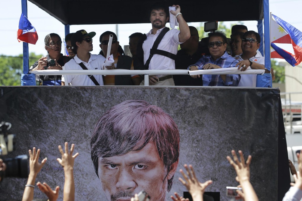 Boxing superstar Manny Pacquiao throws free shirts to a crowd during a motorcade in the streets of Manila. Photo: AP