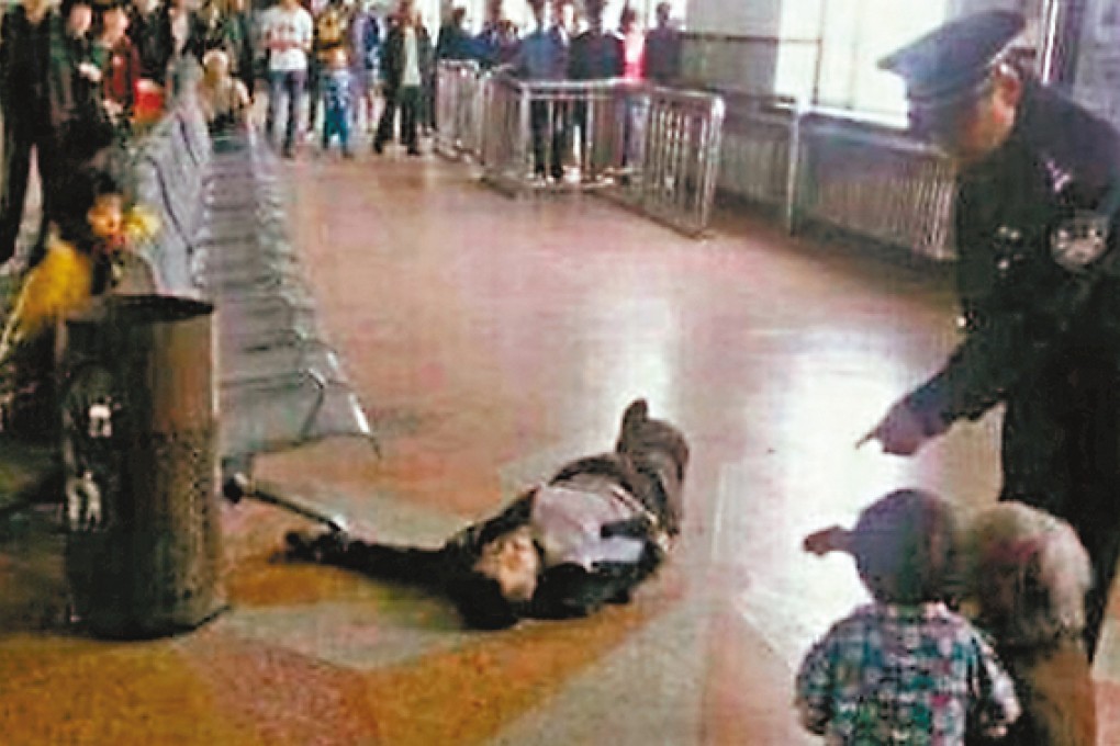 Xu Chunhe lays unconsciously on the ground after being shot by a police officer in front of his children and elderly mother.