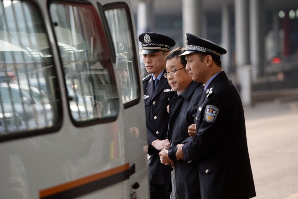 Fraud suspect Li Huabo, centre, is led away by police at Beijing airport earlier this month. He was caught in Singapore. Photo: Xinhua