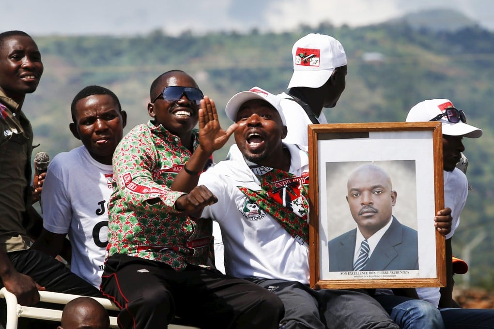 Supporters of Burundi President Pierre Nkurunziza carry his picture as they wait for him to return to the capital, at a street in Bujumbura, Burundi. Photo: Reuters