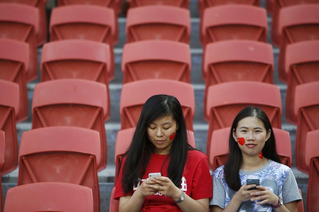 China fans use their mobile phones at a soccer match. Photo: Reuters