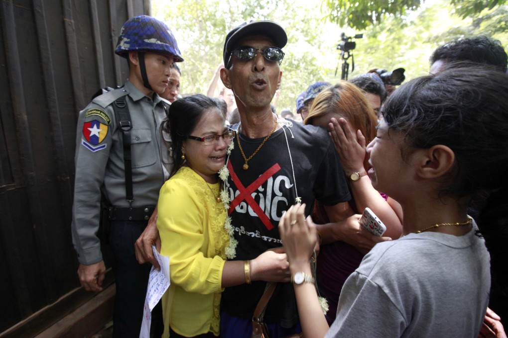 Activist Than Shwe (centre), who protested in front of the Chinese Embassy in Yangon against a Chinese-backed copper mine project, is hugged by crying members of his family. Photo: AP