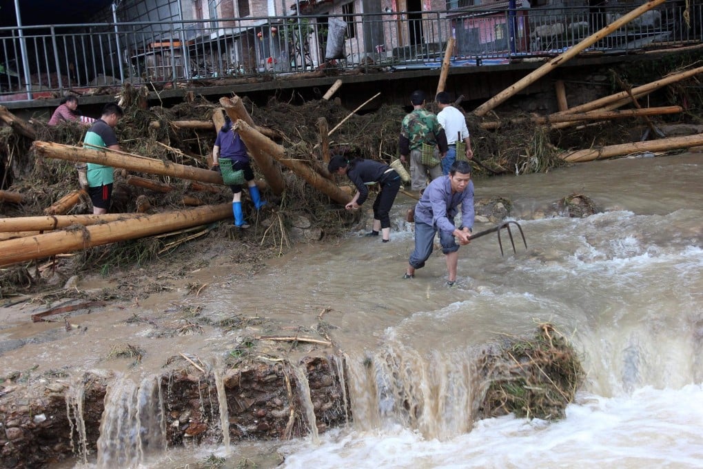 Residents clear debris from a river in Ronghsui county. Photo: Xinhua