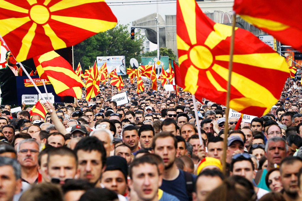 People wave national flags during a protest in front of the Government building in Skopje, Macedonia. Photo: AP