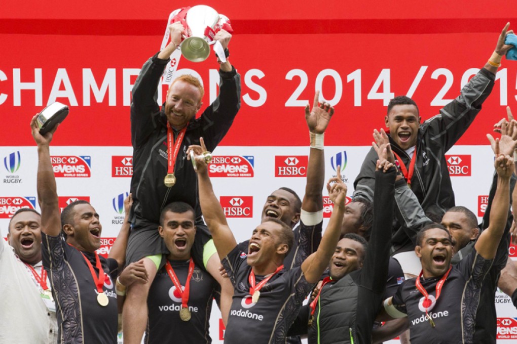Ben Ryan hoists the silverware to finish the season on a high as Fiji celebrate being crowned 2014-15 Sevens World Series overall champions at the end of the London Sevens on Sunday. Photos: AFP