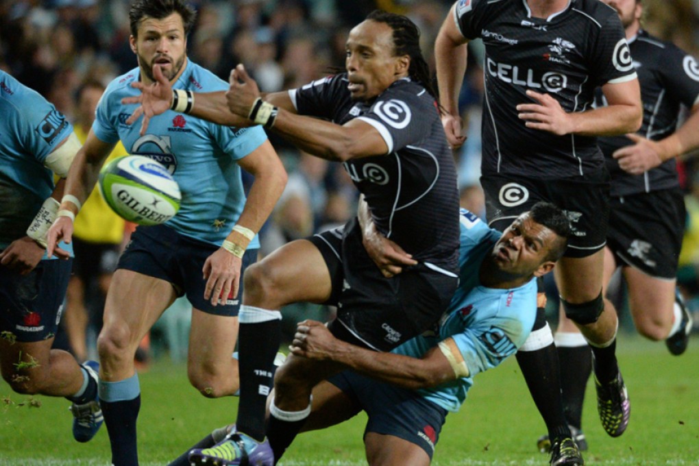 Kurtley Beale of the Waratahs tackles Sharks player Odwa Ndungane during their Super Rugby clash in Sydney on Saturday. Photo: AFP