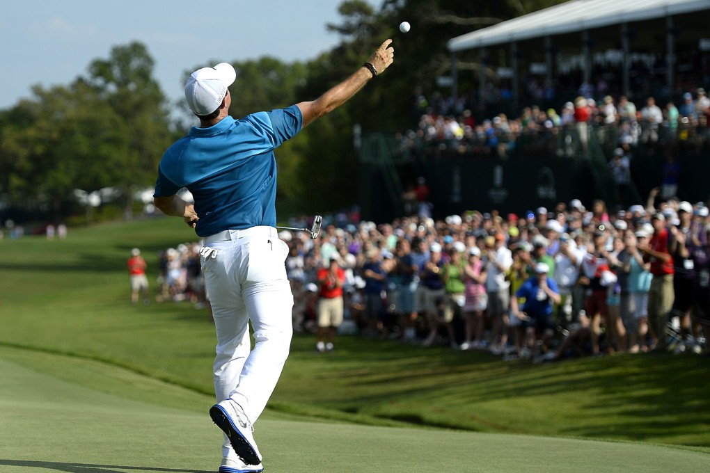 Rory McIlroy throws his golf ball into the gallery after sinking his final putt  at the Wells Fargo Championship at Quail Hollow Club in Charlotte, North Carolina. Photo: Charlotte Observer