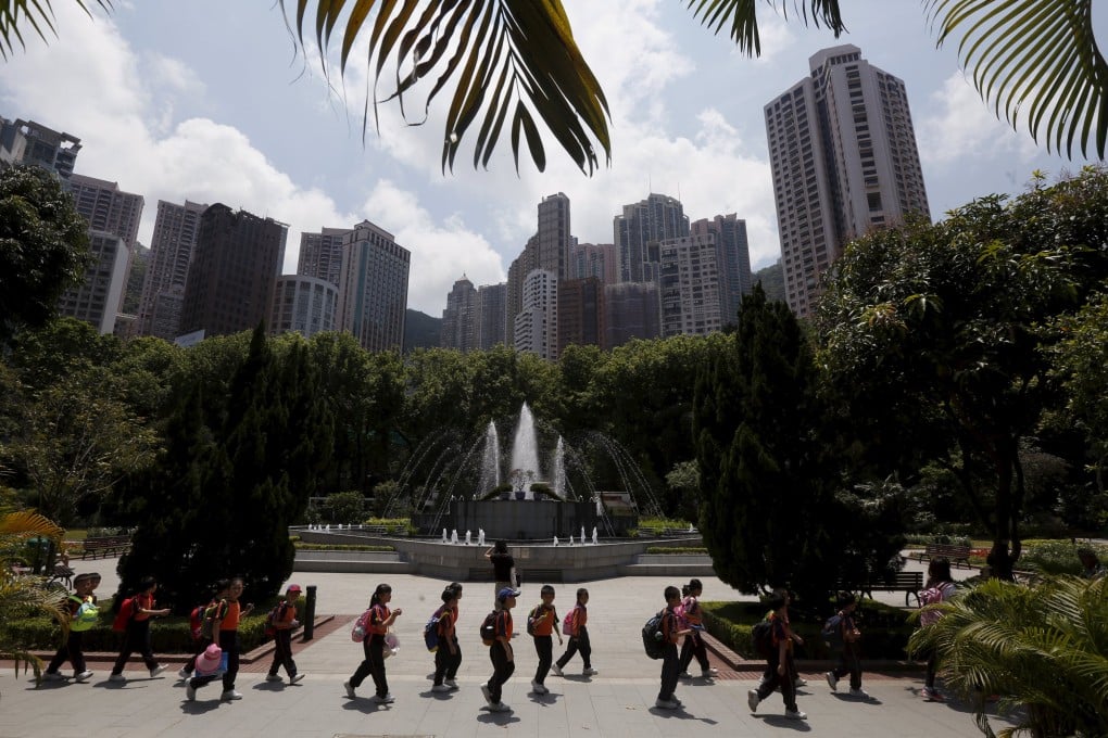 Students walk inside a garden amidst luxury high-rises in the Mid-Levels area of Hong Kong. Photo: Reuters