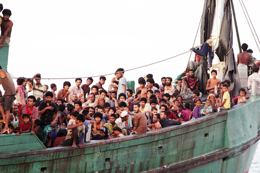 Rohingya and Bangladeshi migrants wait on board a fishing boat before being transported to shore, off the coast of Julok, Indonesia, on Wednesday. Photo: Reuters
