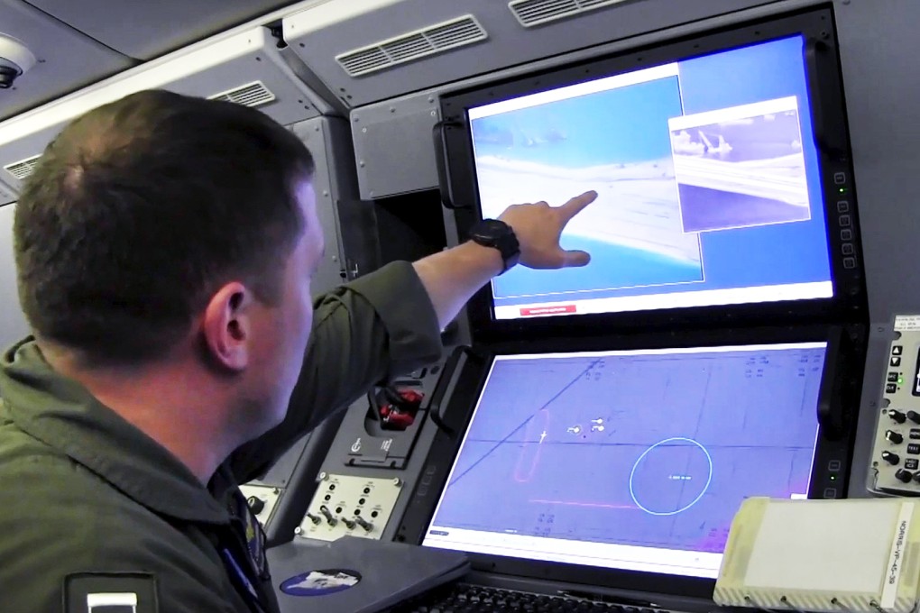 A US Navy crewman on board a P-8A Poseidon surveillance aircraft flying near a Chinese man-made island in the Spratly Islands in a disputed area of the South China Sea. Photo: Reuters