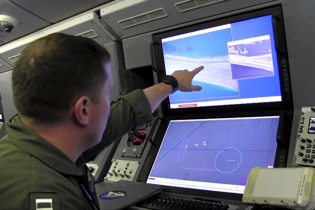 A US Navy crewman aboard a P-8A Poseidon surveillance aircraft views a computer screen purportedly showing Chinese construction on the reclaimed land of Fiery Cross Reef in the disputed Spratly Islands. Photo: Reuters