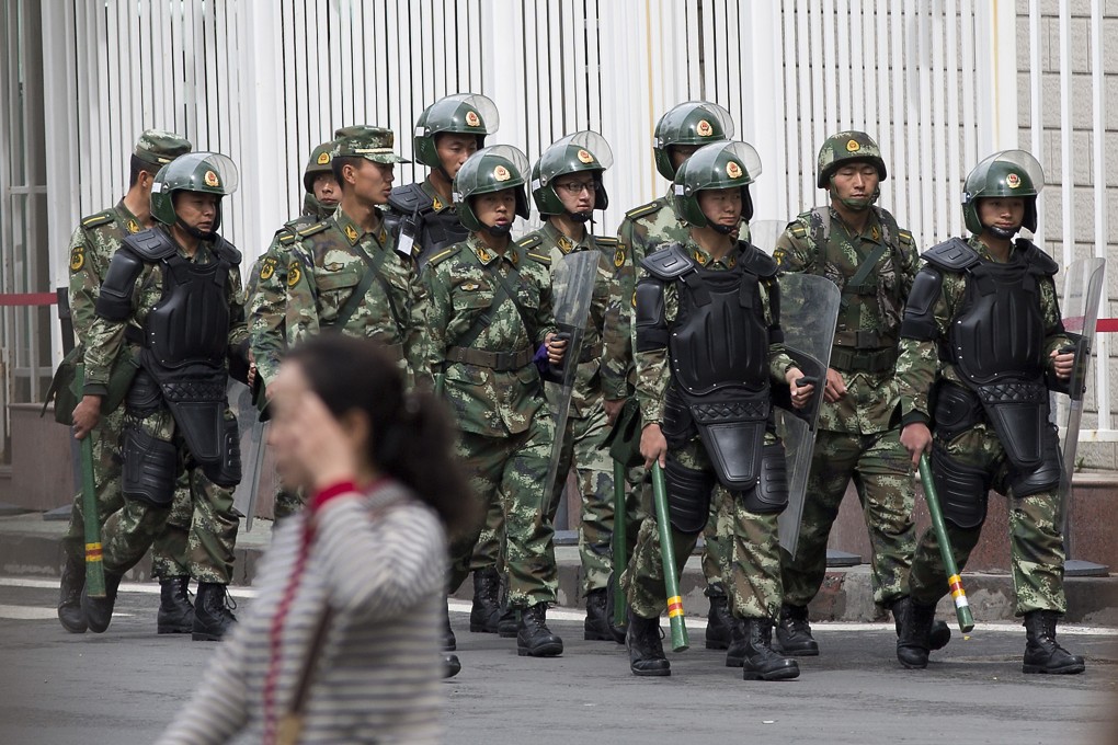 Paramilitary policemen with shields and batons patrol near the People's Square in Urumqi, northwestern China's Xinjiang region. Photo: AP