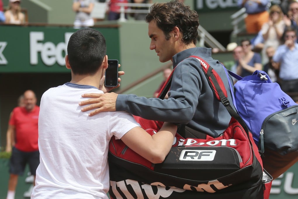 A boy tries to take a selfie with Roger Federer on centre court at the French Open. Federer had just won his first-round match against Colombia's Alejandro Falla when the teenager confronted him. Photo: AP