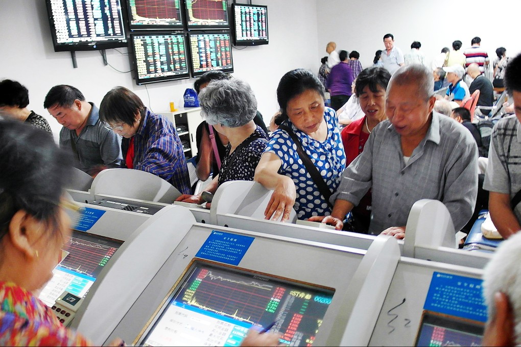 Investors look over stock prices on display terminals at a brokerage house in Yichang, Hubei province. Photo: AP