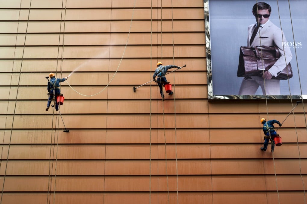 Workers clean the exterior of a building in China as jobs around the world have become less permanent in the aftermath of the 2008 global recession. Photo: Reuters