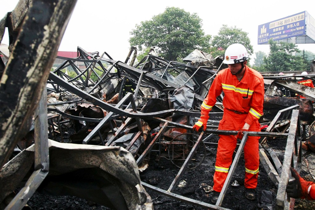 A firefighter removes debris at the scene of the blaze in Pingdingshan. Photo: Reuters