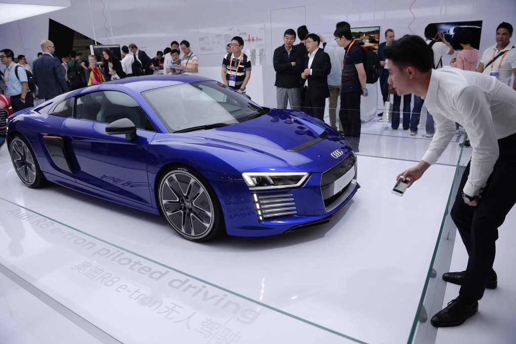 Attendees to the inaugural CES Asia in Shanghai this week look at an Audi electric car. Photo: AP