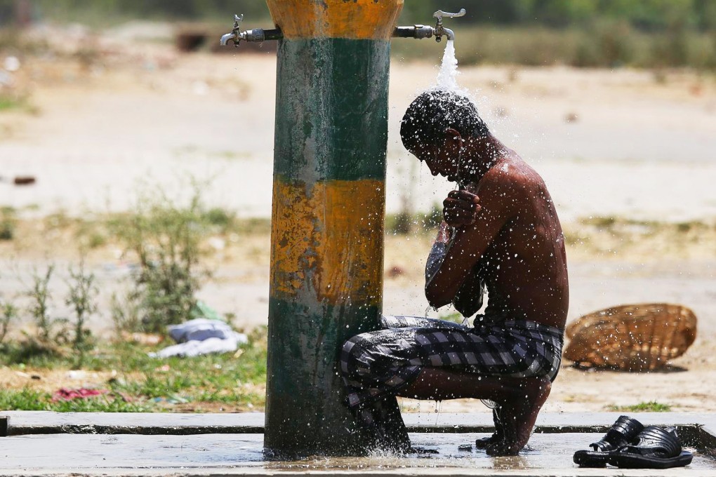 An Indian labourer cools off in Amritsar as NGOs and government organisations work to make drinking water readily available. Photo: EPA