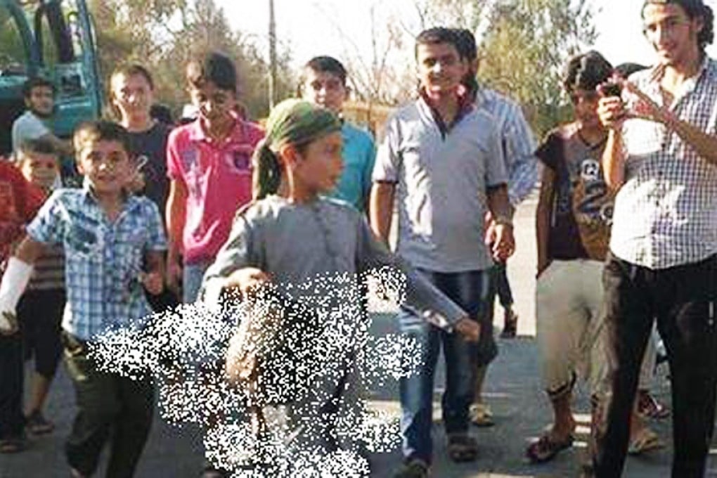 ISIS released photos of a child jihadist parading through the street with a severed head.